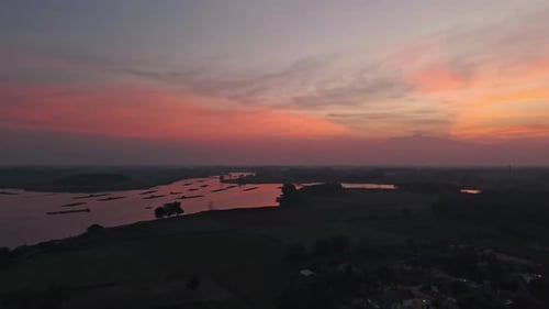 View Of A River Landscape At Sunset With Purple And Pink Skies