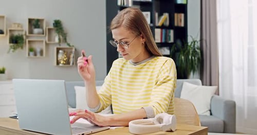 Woman Working on Laptop at Home Desk