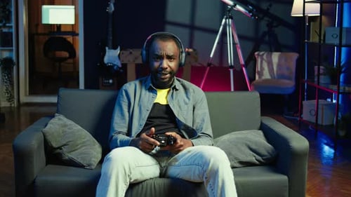 Man Playing Video Games on Couch at Night