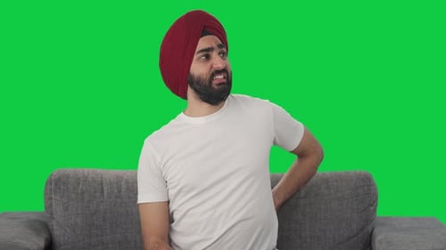 Sick Sikh Indian man suffering from back pain Green screen
