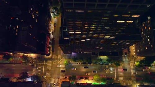 Flyover the well-lit streets of New York with lively traffic at night.