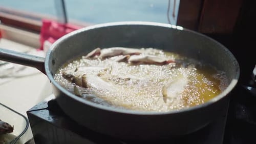 Fish Frying in Hot Oil on a Boat