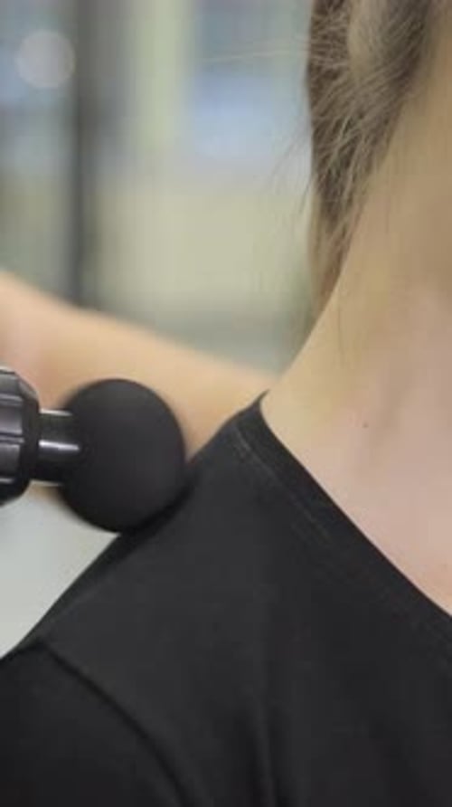 A Rehabilitation Therapy Session with Massage Gun Stimulation for Muscle Recovery and Relaxation in