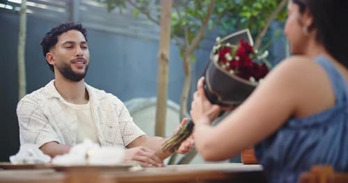 Roses, gift and love with couple in restaurant for valentines day, surprise and romance