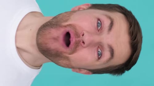 Man Opens Mouth Wide on Turquoise Backdrop