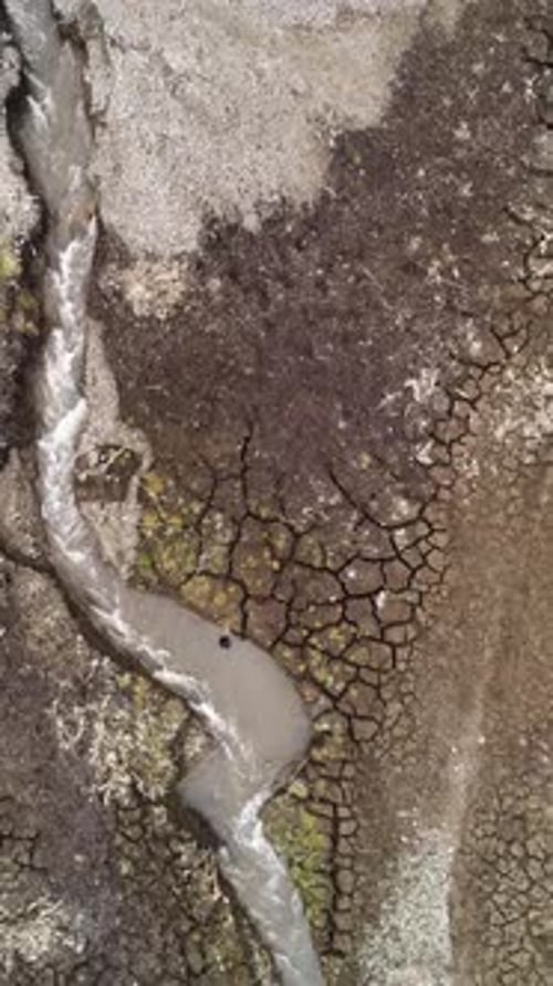 Schmaler Gebirgsfluss, der durch eine felsige Landschaft fließt, ein tief in Steine geschnittenes, senkrechtes Bachbett