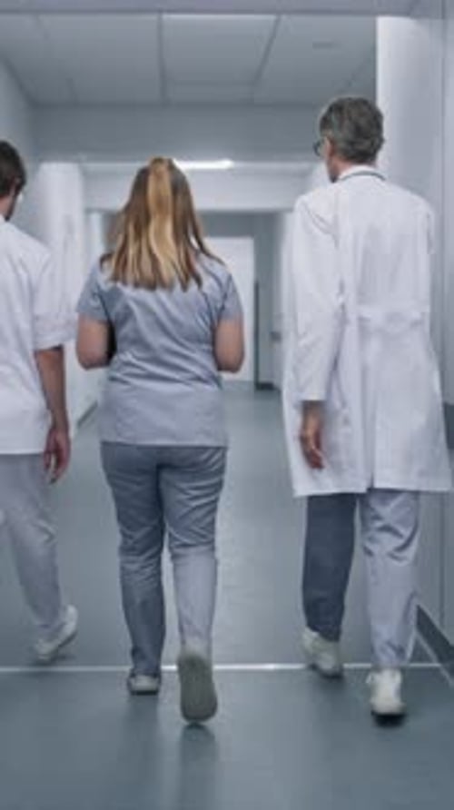 Medical Staff Walk Along the Modern Clinic Corridor