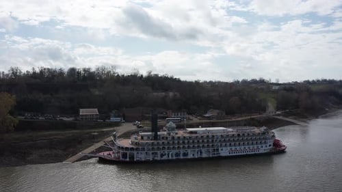 Push-in and panning aerial shot of the river cruise ship American Queen docked at the Port of Natche