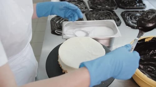 Baker Decorates a Cake with Chocolate in Kitchen