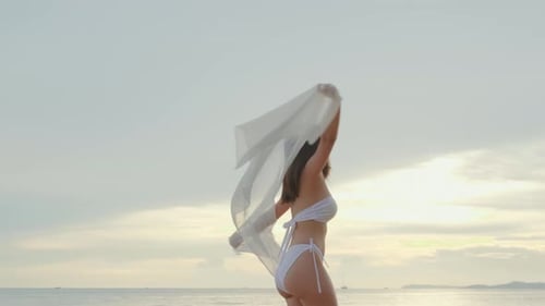 Woman Wear Bikini Swimsuit with Blowing Sarong Enjoying Walking and Spin Body at Beach