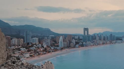 Seafront city at beautiful pink sunset hour. Modern buildings and skyscrapers.