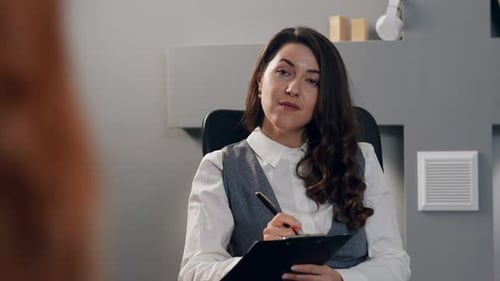 Professional Woman Taking Notes in Modern Office Setting