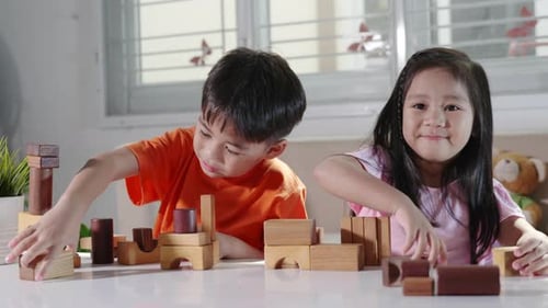 Children boy and girl playing with constructor wooden block building