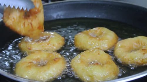 A kuih keria está sendo frita com óleo de cozinha em uma panela quente. É um bolo malaio tradicional. Feito de