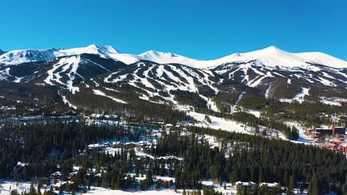 Mountains Covered in White Snow with Ski Slope Trails. Beautiful Aerial Drone View of Cold Winter We