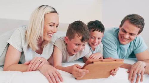 Happy Family Laughing Together While Using Tablet