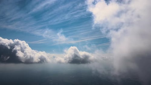 Aerial View From Airplane Window at High Altitude of Earth Covered with White Puffy Cumulus Clouds