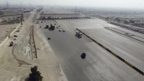 Vista superior de uma praça de pedágio da cidade, veículos pesados e outros entrando e atravessando.