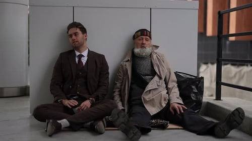 Men Sitting Against a Wall Outdoors