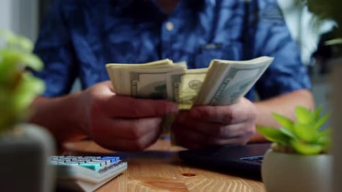 Close Up Of Financial Planning At Kitchen Table With 100 Dollar Bills