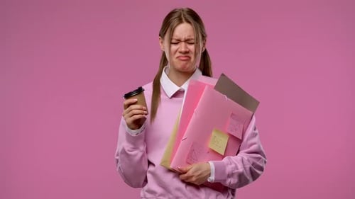 A Young Female Student is Upset About Her Failure Holding Folders and Notes in Her Hands