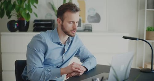 Man Attending Virtual Meeting at Desk
