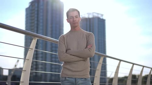 Young Adult Stands with Arms Crossed in Urban Setting