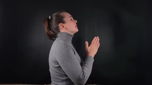 A Woman Interacting with an Object Isolated on the Black Backdrop