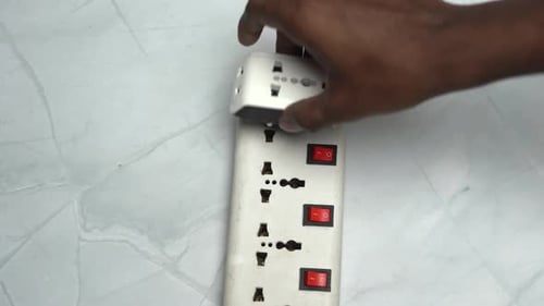 Plugging a White Adapter into a Power Strip