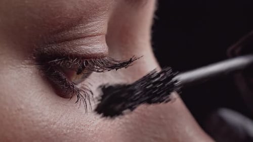 Woman Applies Black Mascara in Close Up Shot