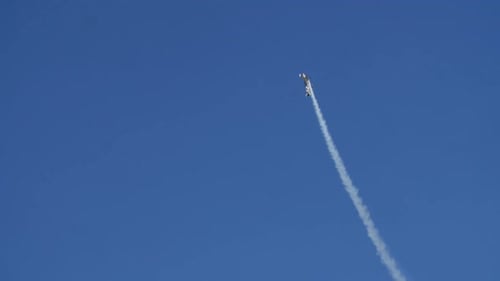 Airplane executes steep spinning climb at Oeiras airshow with smoke trail