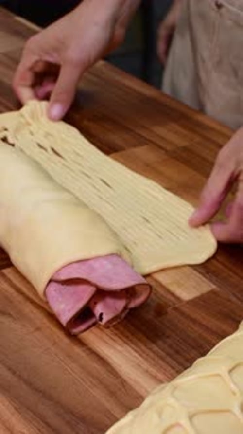 Preparing Stuffed Ham Dough Roll on Wooden Board. Homemade baking and savory pastry recipe
