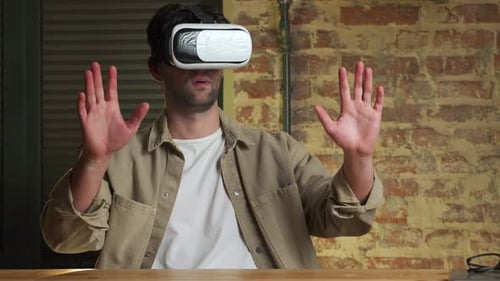 Young Man Wearing Virtual Reality Glasses in a Coworking Studio of Modern Interior Design