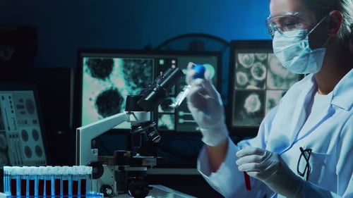 Female Scientist Working with Microscope and Test Tubes