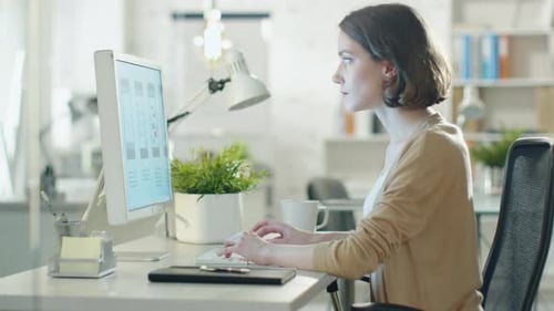Creative Brunette Working on Design at Her Desktop Computer. Sitting in Her developer Office.