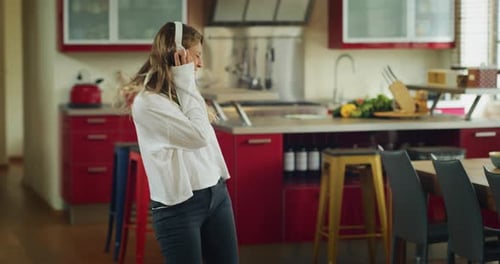 Authentic close up shot of an young carefree happy woman wearing white headphones is having fun to