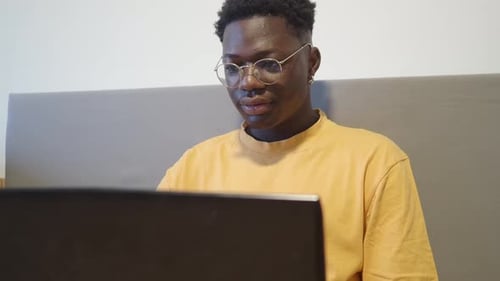 Young Adult Working on Laptop in Bedroom