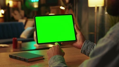 Shot of Man Holding Scrolling and Tapping on Tablet Computer with Horizontal Green Screen Mock Up