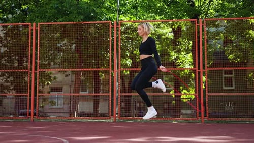 Woman Skipping Rope on Outdoor Court