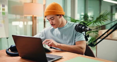 Tablet, laptop and man with mic in studio for podcast, editing broadcast and recording with tech