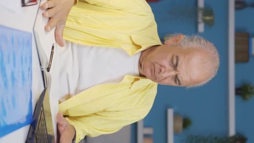 Vertical video of Home office worker old man working with concentration.
