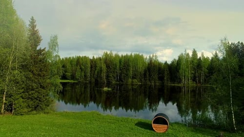 Aerial low view of lake middle of the forest surrounded pine trees. Coniferous forest in the summer