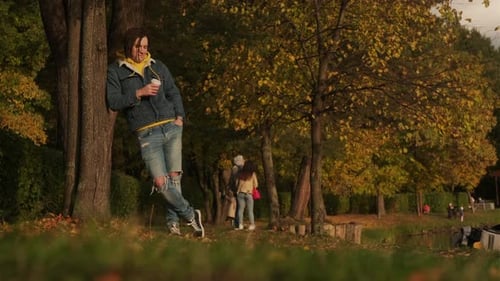 Man Drinking Coffee Outdoors in Fall Foliage