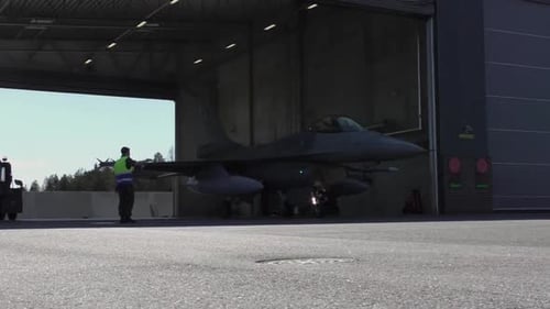 Fighting Falcon jet leaves the airdock on his way to the runway, to launch and take off. Medium shot