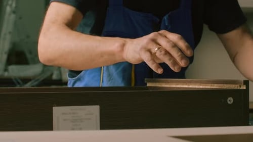 Men in special clothes with perforated boards and boards are trying to assemble furniture