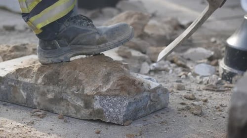 A Construction Worker is Stepping Purposefully on a Block of Stone Demonstrating Their Role