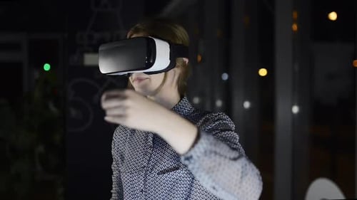 Businesswoman In The Office Wearing Virtual Reality Goggles.