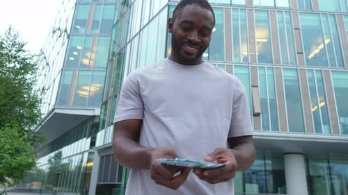 African American Man Holding Money Dollar Bills on Urban Street in City Businessman Guy Counting