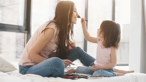 Apprendre à se maquiller. Jeune mère avec sa fille passant le week-end ensemble dans la chambre
