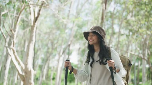 Joyful Asian female hiker smiles while enjoying a walk